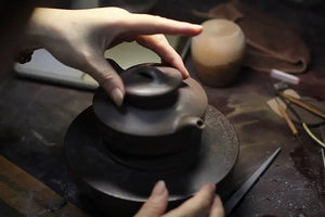 Fitting the lid and checking its alignment with the teapot body